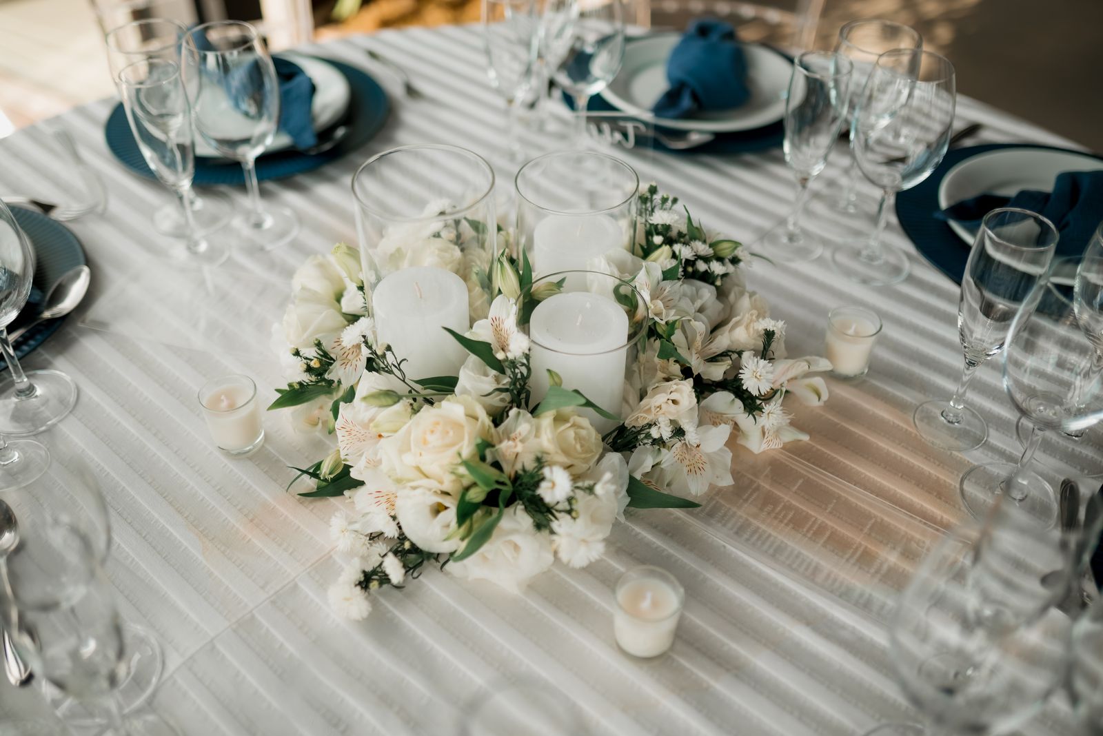 Eingedeckter Hochzeitstisch mit Kerzen und weißen Blumen
